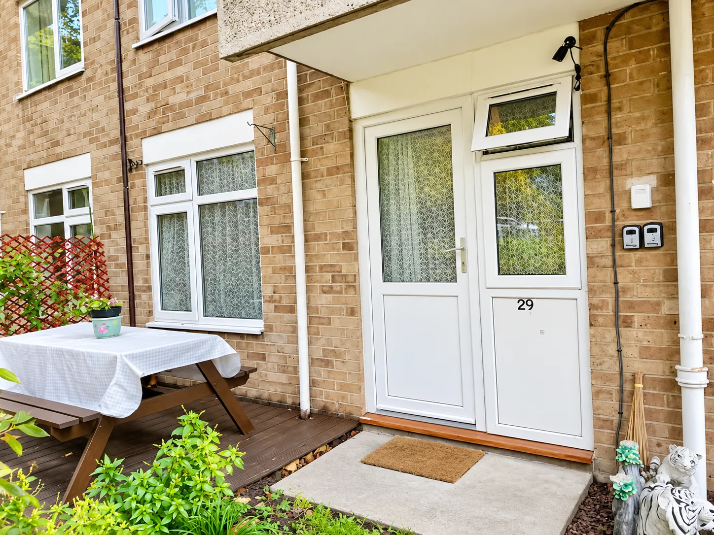 White front door marked 29 beside a small garden